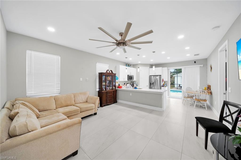 Living area with ceiling fan, recessed lighting, and light tile patterned flooring