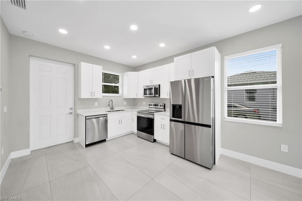 Kitchen featuring stainless steel appliances, white cabinets, recessed lighting, and light tile patterned floors
