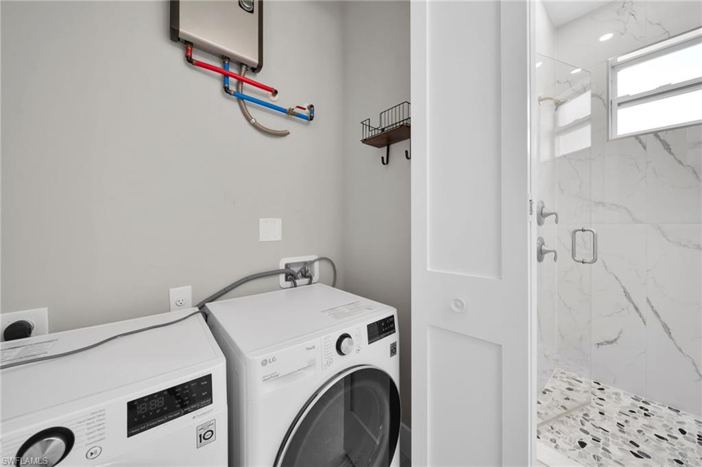 Laundry area featuring water heater and separate washer and dryer