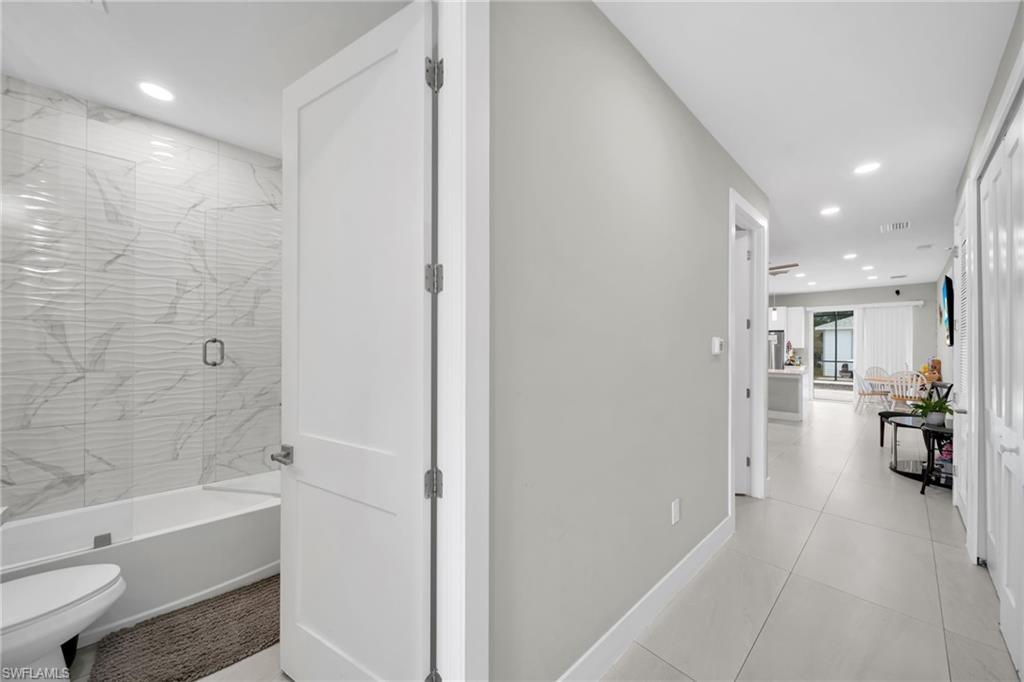Hallway featuring recessed lighting and light tile patterned flooring