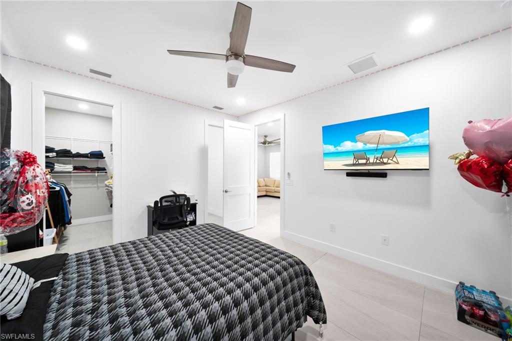 Bedroom featuring a walk in closet, a ceiling fan, recessed lighting, and light tile patterned floors