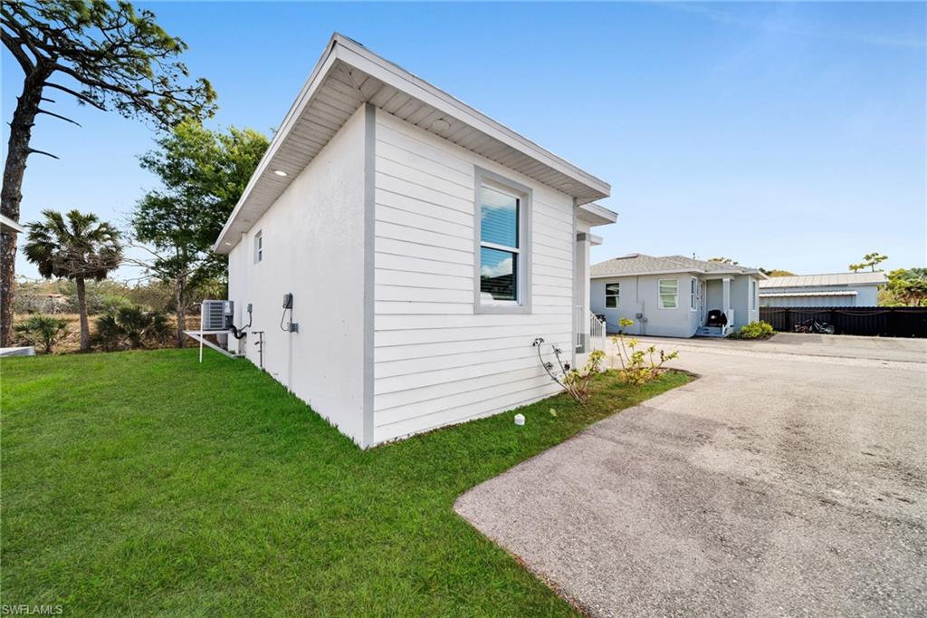 View of property exterior with a lawn and a cooling unit
