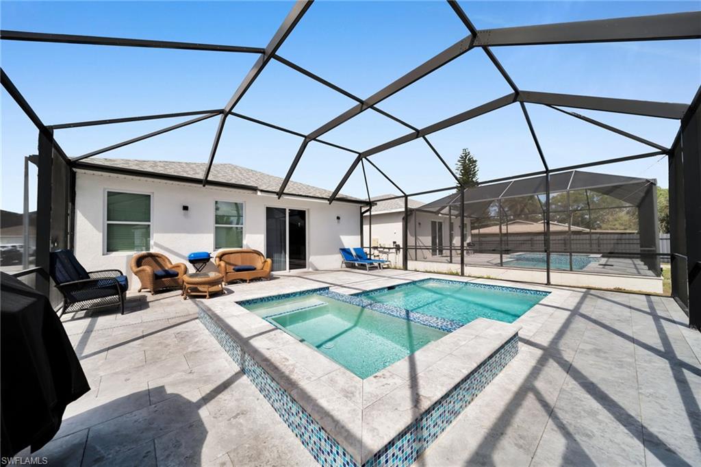 Combined pool / hot tub with a sunroom, a lanai, and a patio