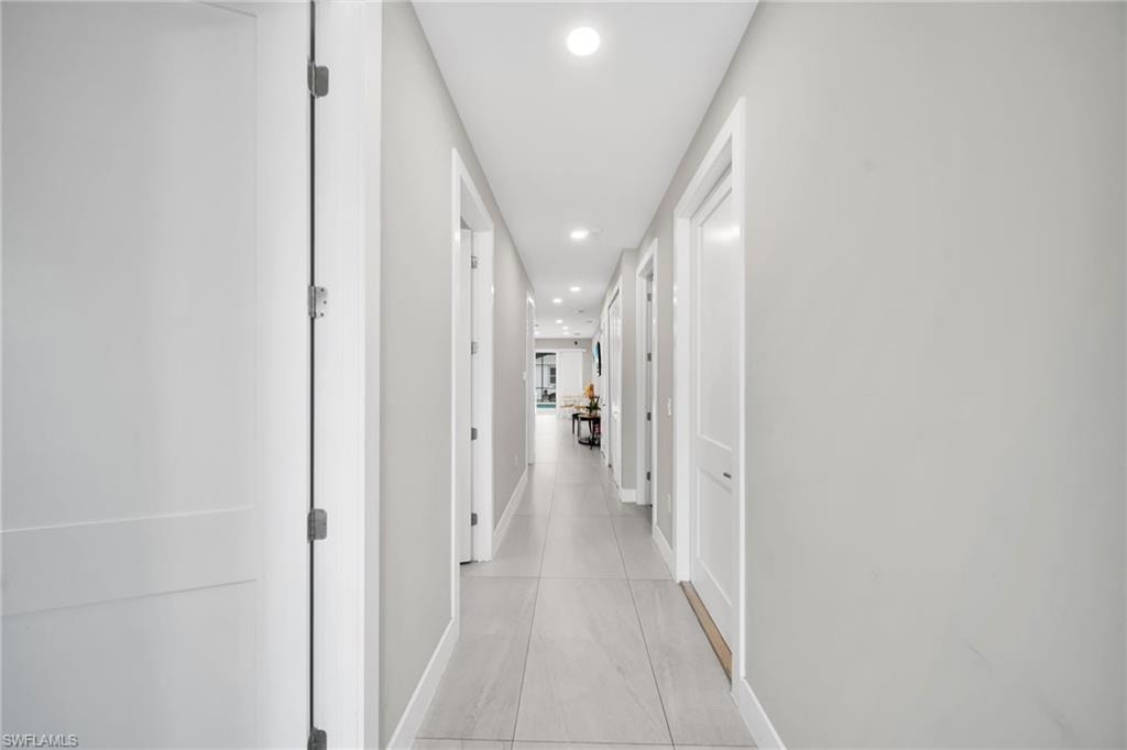 Hallway with recessed lighting and baseboards