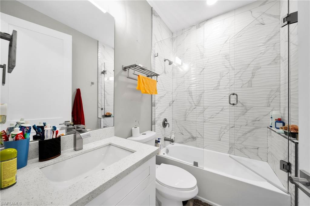 Full bath featuring vanity and combined bath / shower with glass door