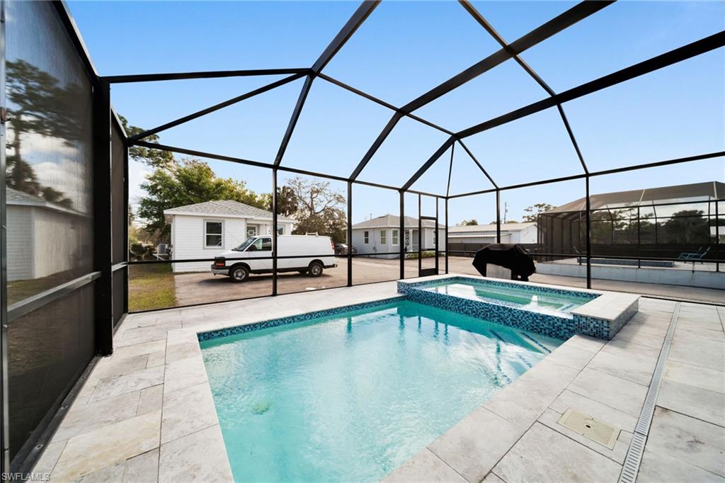 Integrated pool / hot tub featuring a lanai, a sunroom, and a patio