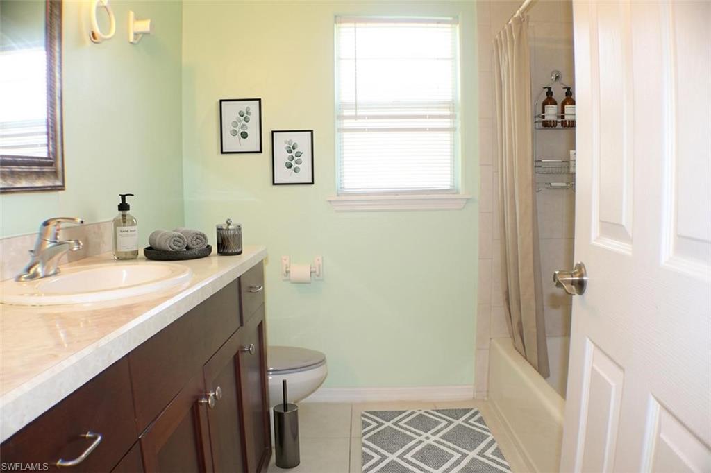 Full bathroom with vanity, light tile patterned floors, and shower / bath combo