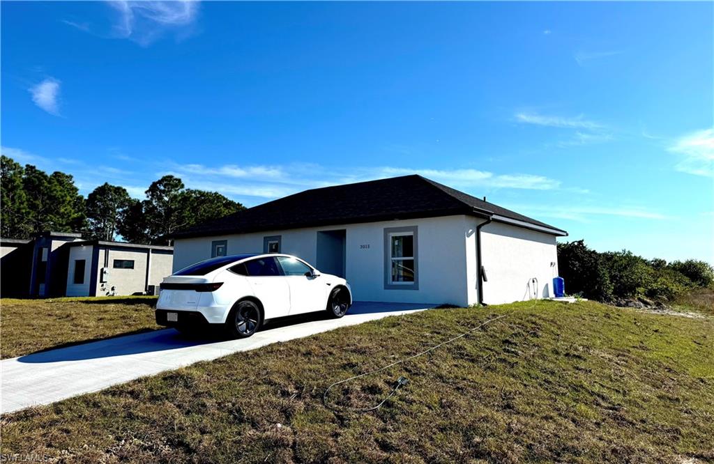 Ranch-style house with a front lawn and stucco siding