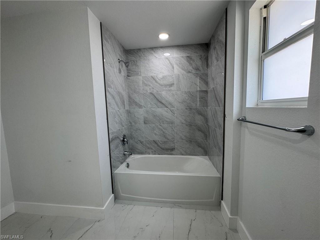 Full bathroom featuring shower / bathtub combination, recessed lighting, and light marble finish floors