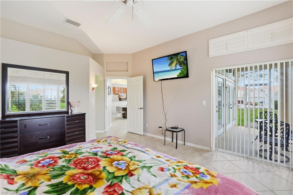Bedroom with access to exterior, multiple windows, light tile patterned floors, and ceiling fan