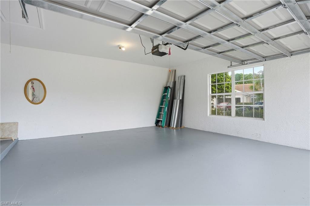 Garage with a textured wall and a garage door opener