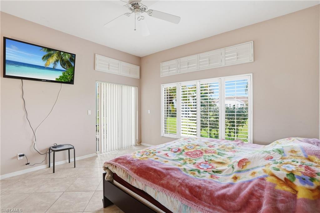 Bedroom with access to exterior, light tile patterned flooring, and a ceiling fan