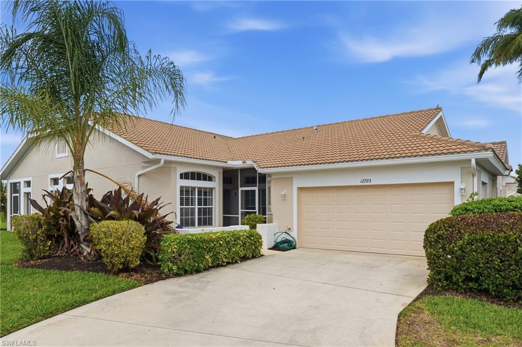 View of front facade featuring an attached garage, stucco siding, concrete driveway, and a tiled roof