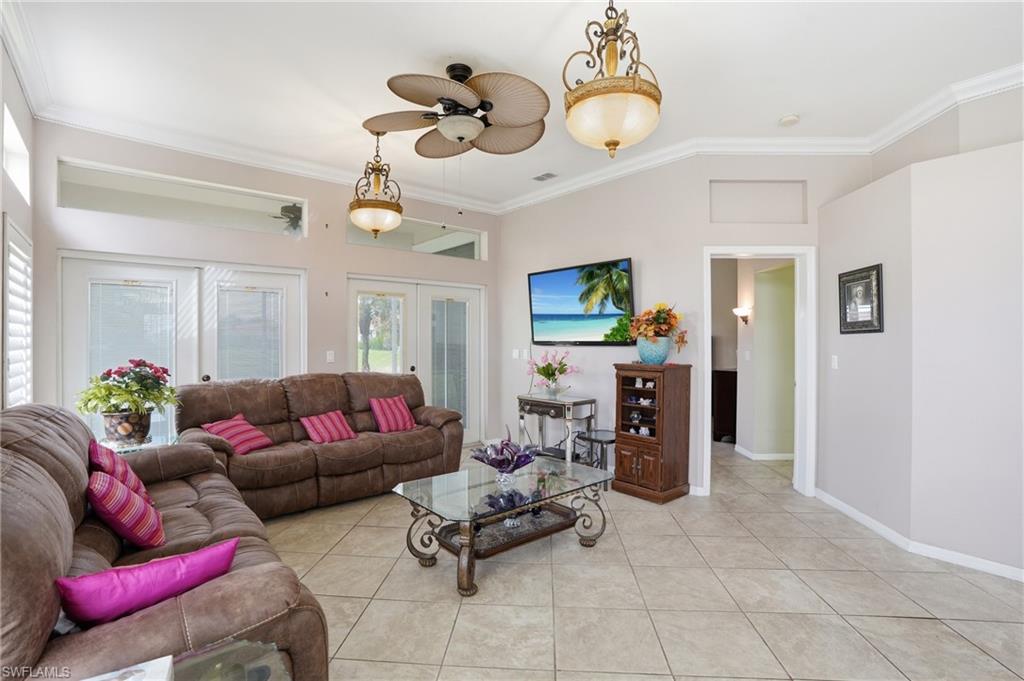 Living area featuring ornamental molding, french doors, a ceiling fan, and light tile patterned floors