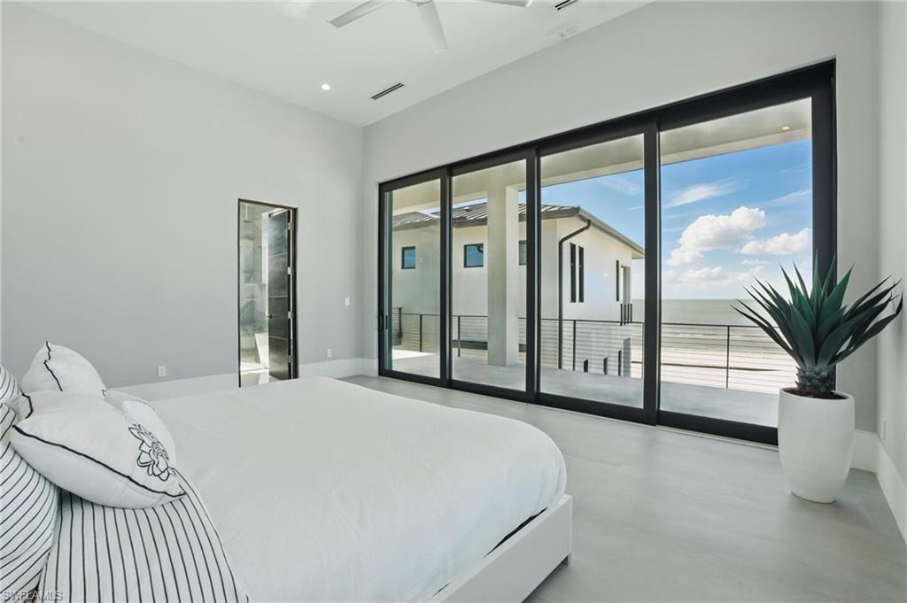 Bedroom featuring access to outside, concrete flooring, and ceiling fan Virtually Enhanced