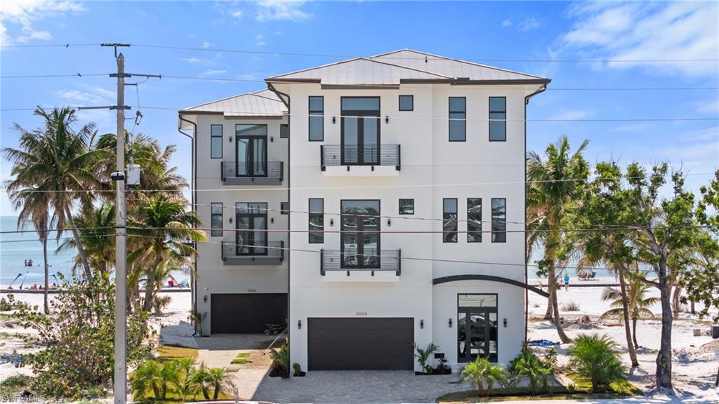 Contemporary home with stucco siding, decorative driveway, and a garageVirtually Enhanced