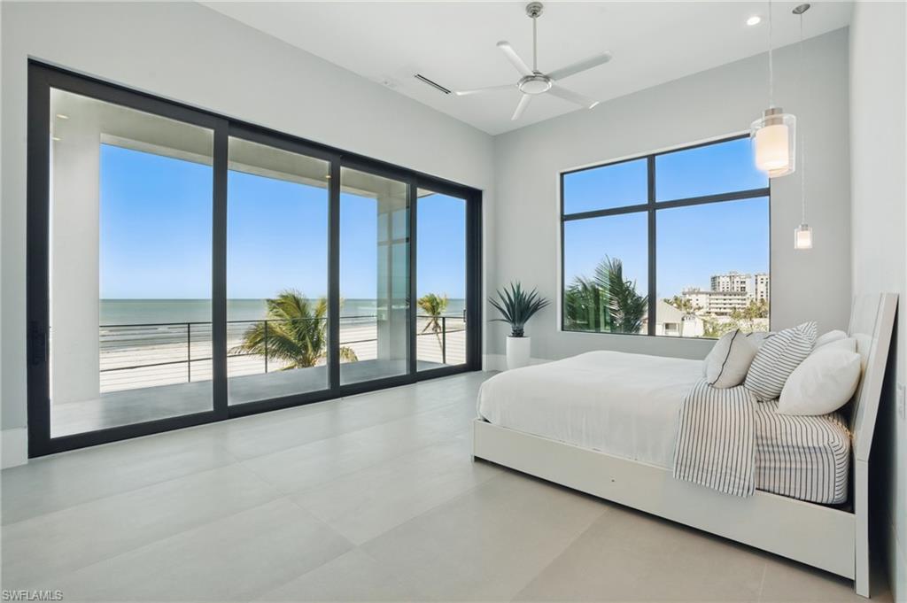 Bedroom featuring access to exterior, a water view, and a ceiling Virtually Enhanced