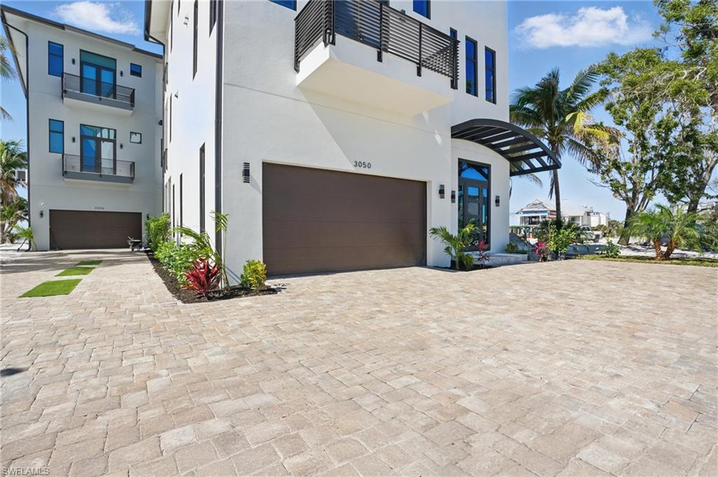 Contemporary house featuring stucco siding, an attached garage, and driveway Virtually Enhanced