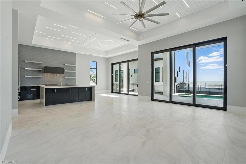 Unfurnished living room with ceiling fan and a wood tray ceilingVirtually Enhanced