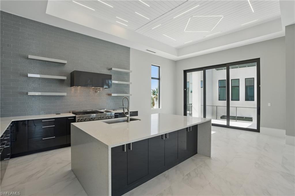 Kitchen featuring dark cabinets, open shelves, light stone counters, modern cabinets, and wooden ceiling Virtually Enhanced