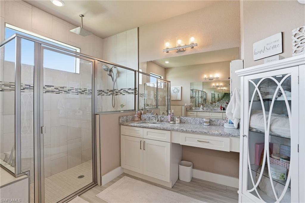 Bathroom featuring vanity and a stall shower with large rain shower head