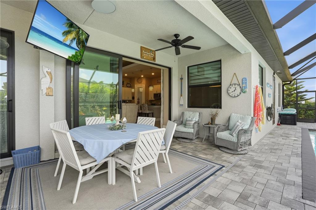 View of patio with a lanai, outdoor dining space, and ceiling fan