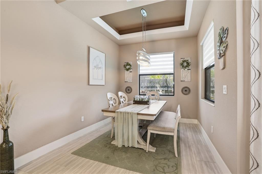 Dining area featuring a raised ceiling and baseboards