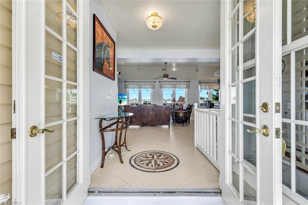 Foyer entrance featuring light tile patterned floors, ceiling fan, and french doors