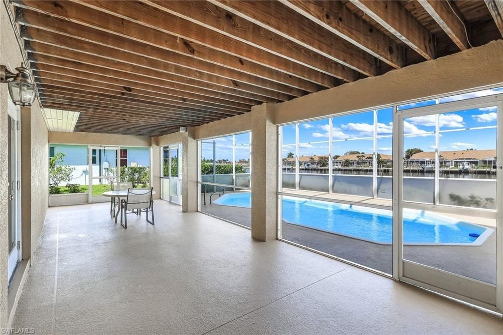 Outdoor pool with a water view, outdoor dining area, and a patio area