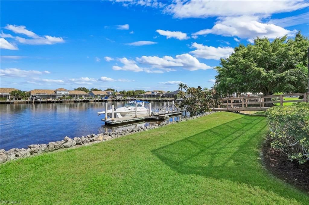Dock area featuring a lawn, a water view, and a residential view