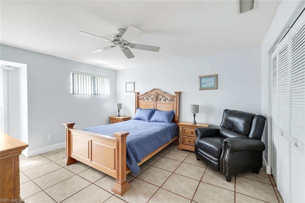 Bedroom featuring a closet, ceiling fan, and light tile patterned floors