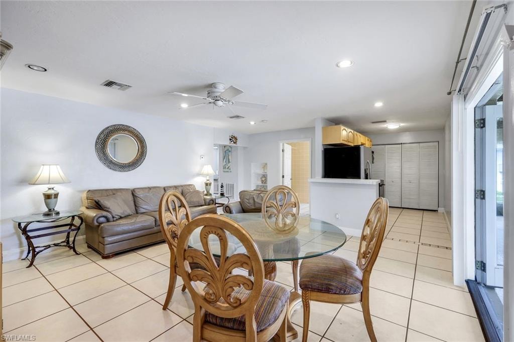 Dining space featuring light tile patterned floors, ceiling fan, and recessed lighting