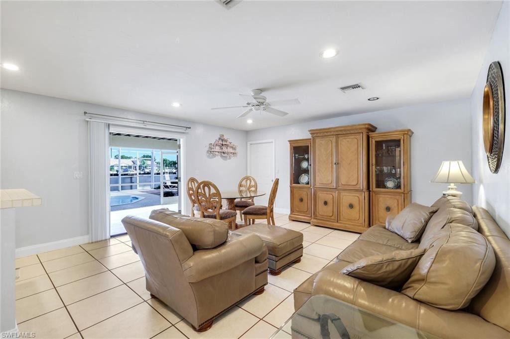 Living area featuring ceiling fan, light tile patterned flooring, and recessed lighting