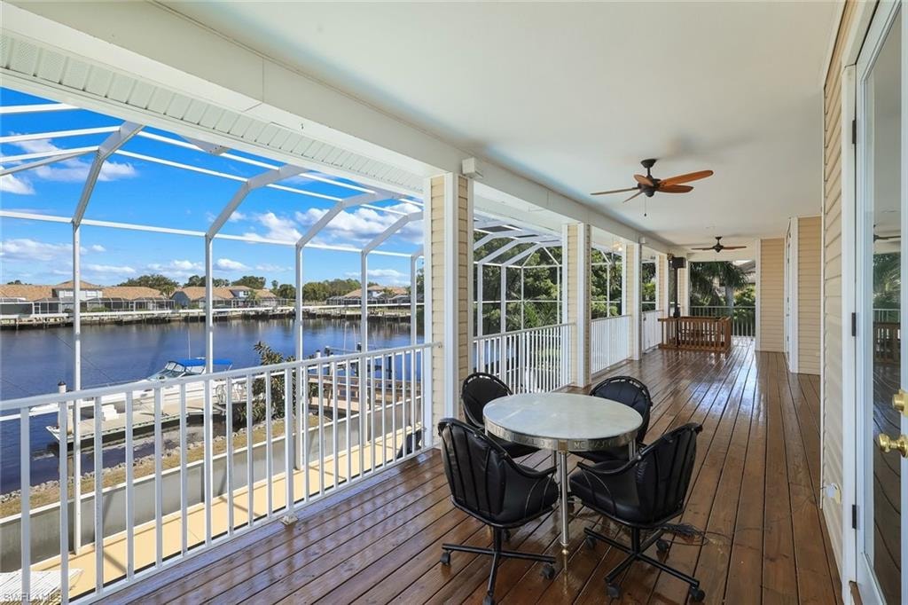 Sunroom / solarium with outdoor dining area, a water view, and a residential view