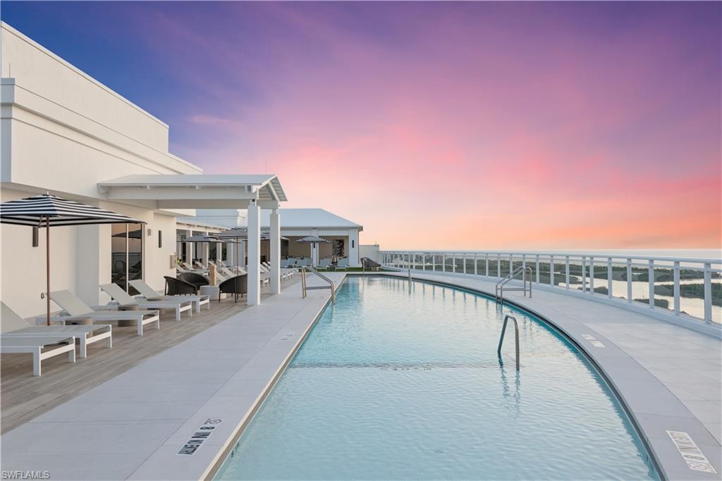Pool at dusk featuring a community pool and a patio