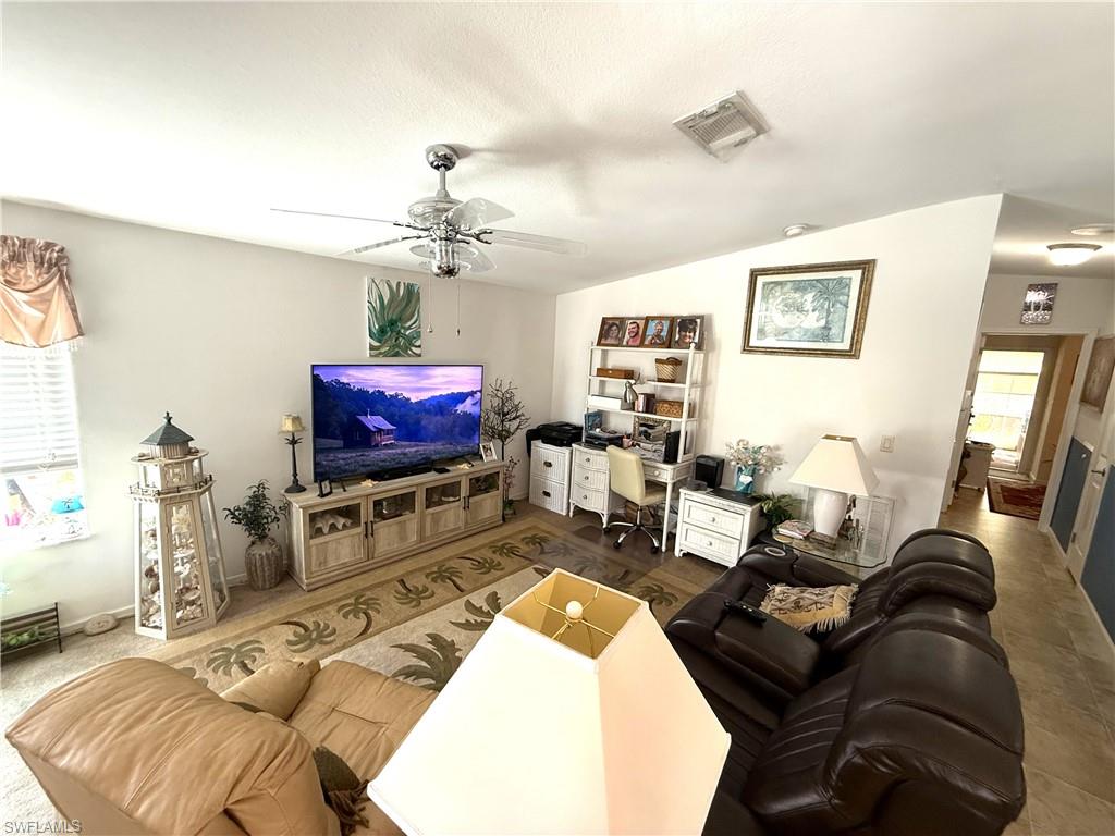 Living room featuring ceiling fan, lofted ceiling, and an office area