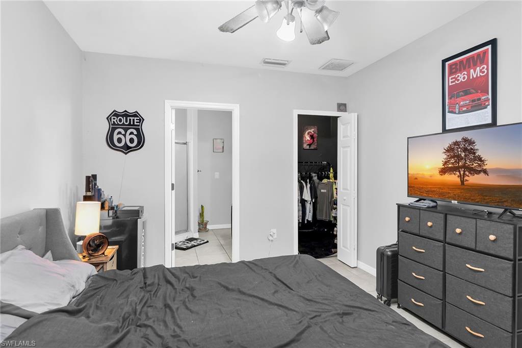 Bedroom with a walk in closet and ceiling fan