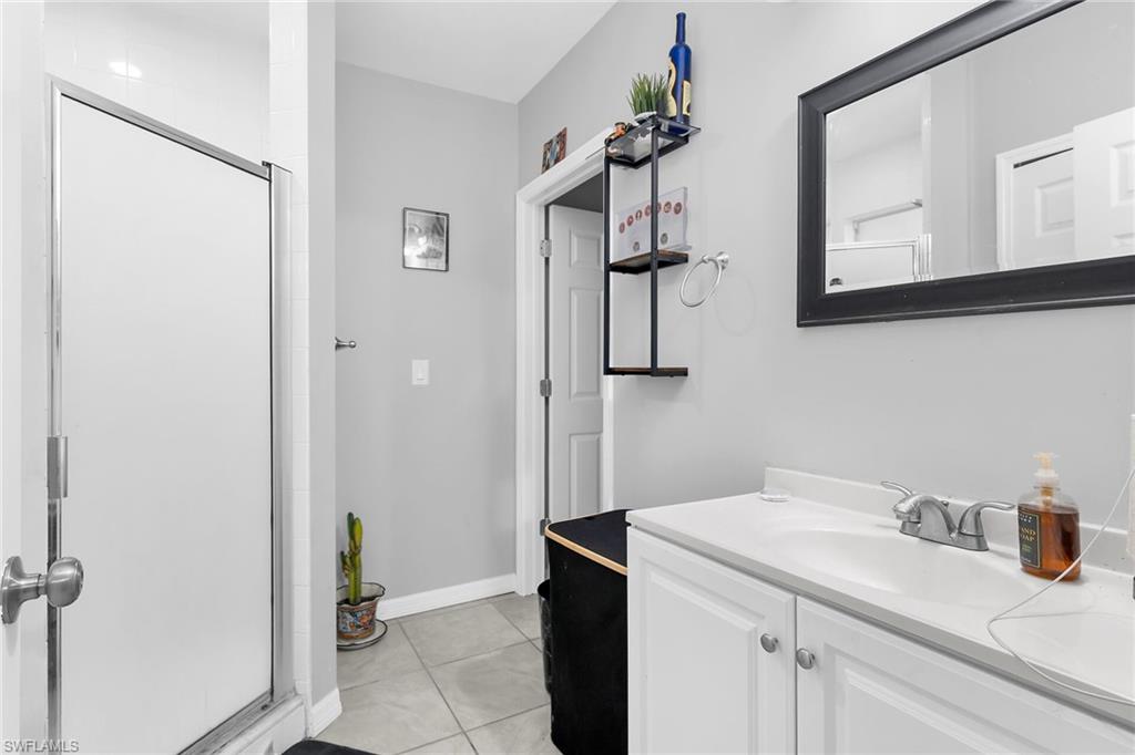 Bathroom featuring vanity, a stall shower, and light tile patterned floors