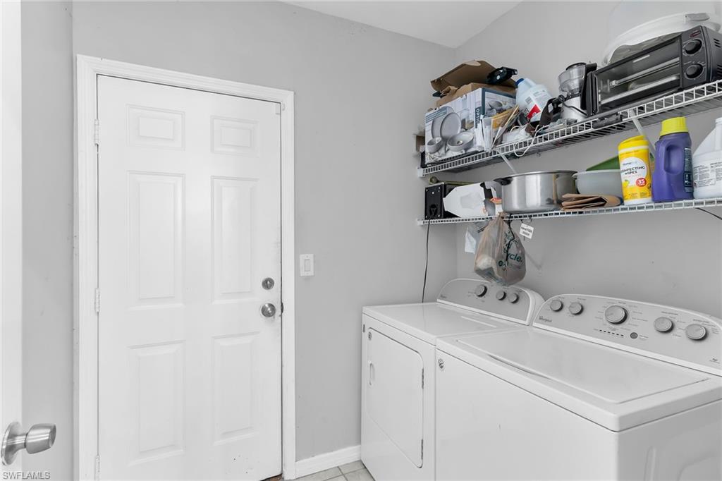 Laundry room featuring washing machine and dryer and baseboards