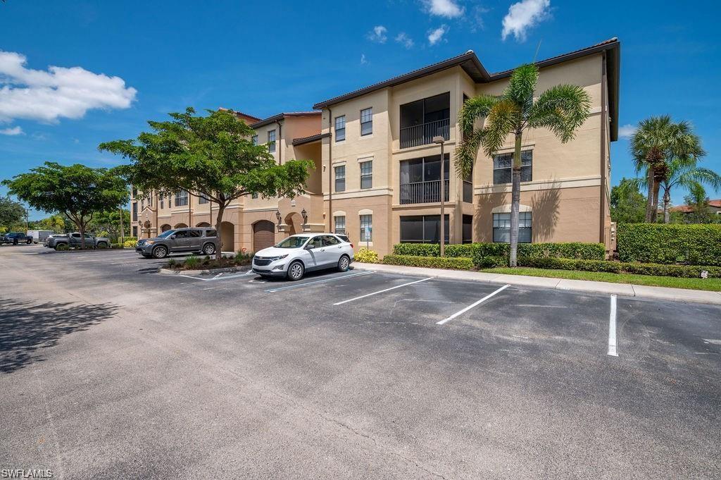 View of apartment building / complex featuring uncovered parking