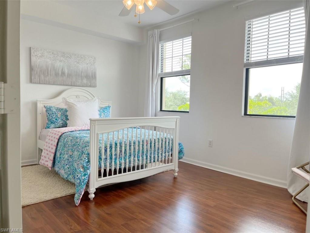 Bedroom with dark wood finished floors and a ceiling fan