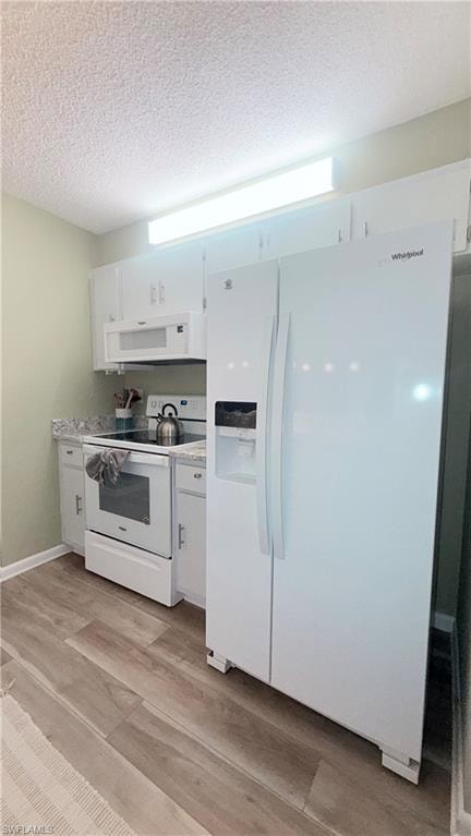 Kitchen featuring white appliances, light wood finished floors, white cabinetry, and a textured ceiling
