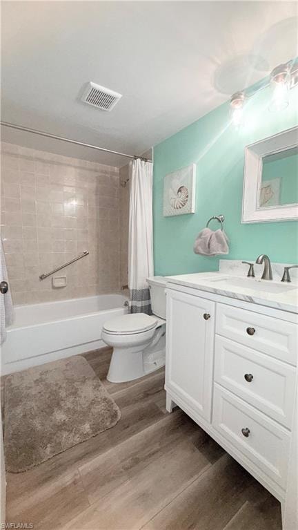 Full bathroom with vanity, shower / bath combo, and wood finished floors