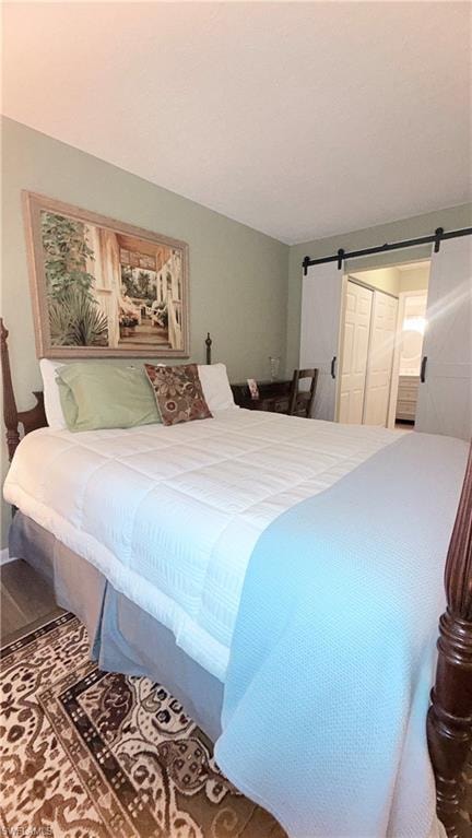 Bedroom featuring a barn door and a closet