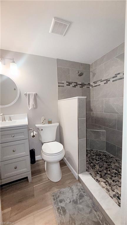 Full bathroom with vanity, a walk in shower, and light wood-style floors