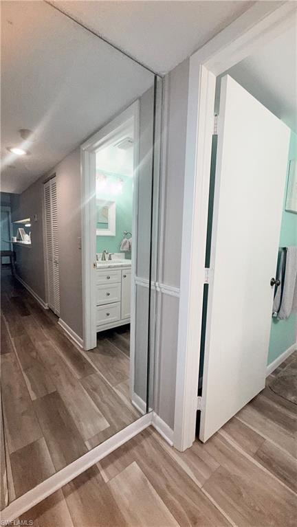 Hall featuring light wood-type flooring and baseboards