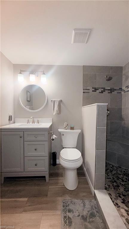 Full bath with a walk in shower, vanity, and light wood finished floors