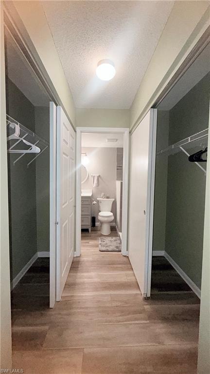 Hallway with light wood-style floors and a textured ceiling