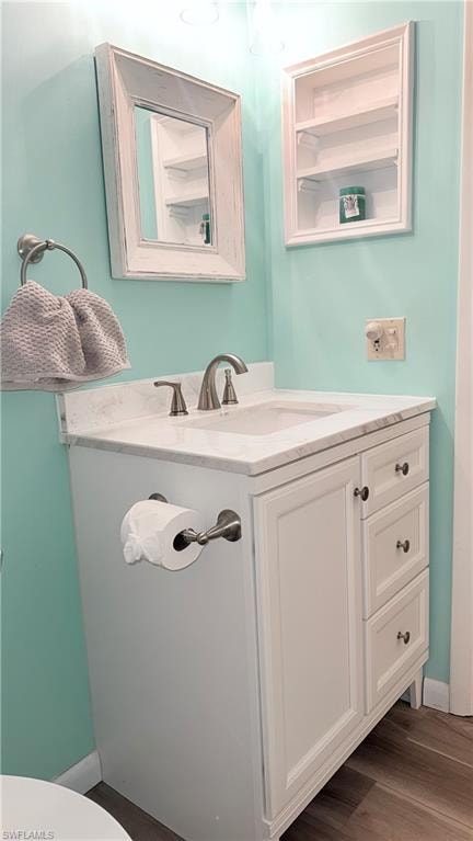 Half bathroom with vanity and dark wood-style flooring