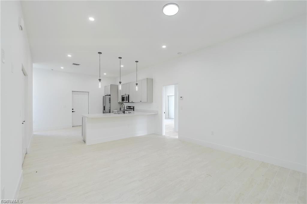 Unfurnished living room featuring light wood finished floors and recessed lighting